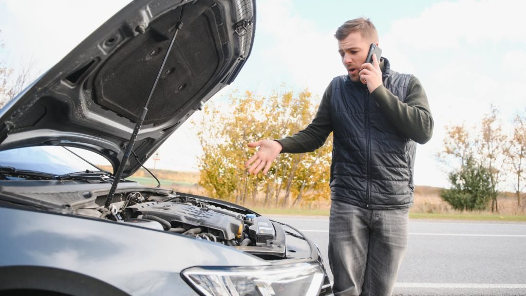 Man checking his broke down car